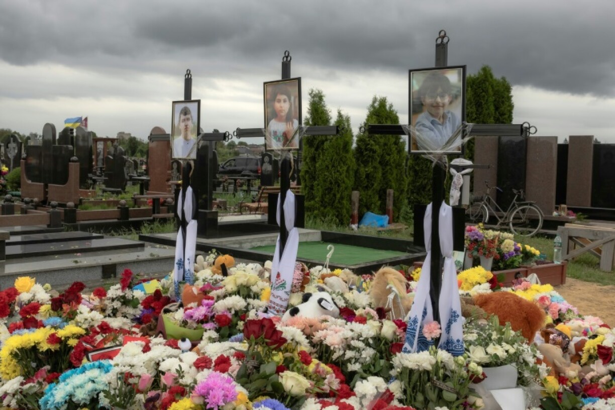 Flowers and toys are placed over the graves of Roman Martyniuk, 17, his sister Tamara, 11, and brother Stanislav, 8, who were killed by a Russian missile strike