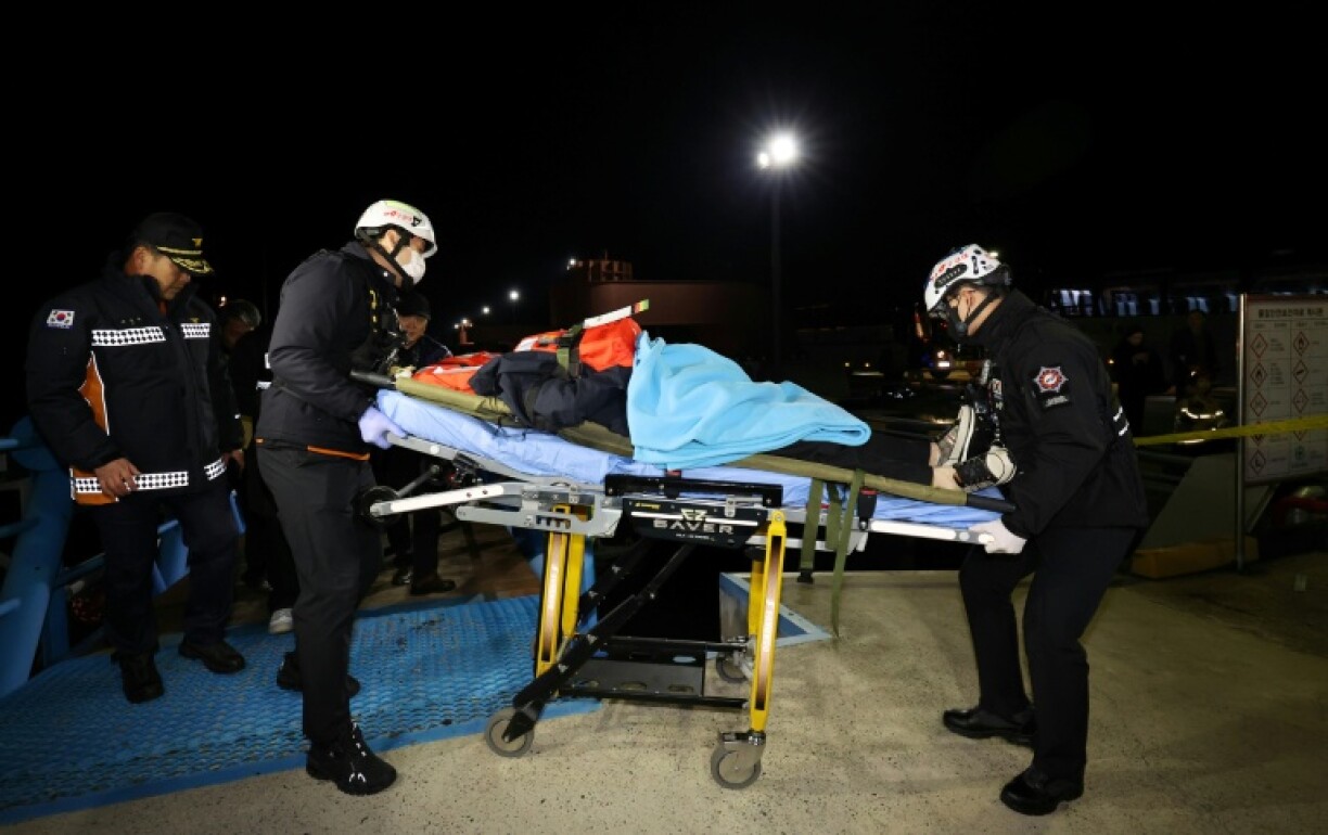 Rescuers carry a passenger from a ferry that run aground in South Korea