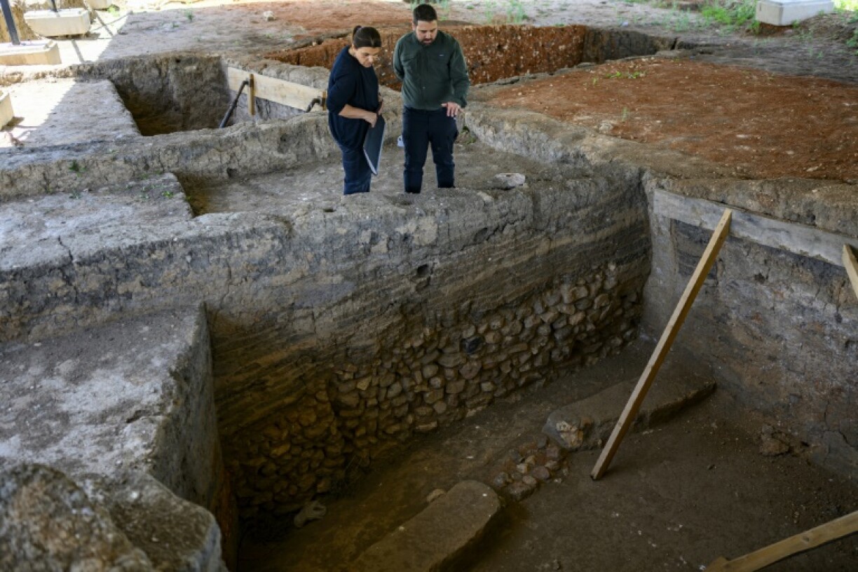 Archaeologists Murat Turkteki and Deniz Sari examine an ancient house at the Kulluoba excavation site in central Turkey