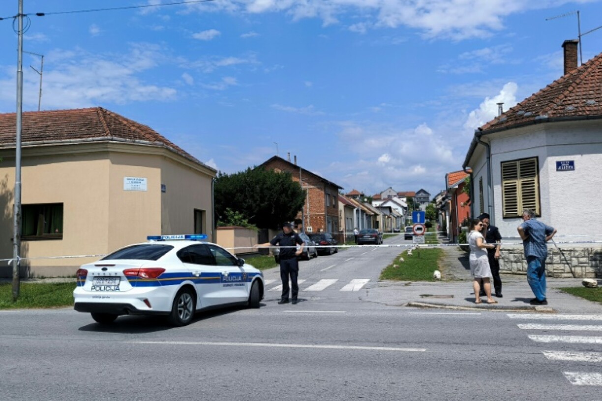 Un officier de police monte la garde à proximité d'une maison de retraite (à gauche) où six personnes ont été tuées lors d'une fusillade à Daruvar, à environ 130 km de Zagreb, le 22 juillet 2024