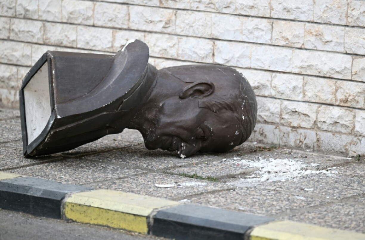 A toppled bust of Assad's father and predecessor Hafez lies discarded on the pavement outside the defence ministry complex