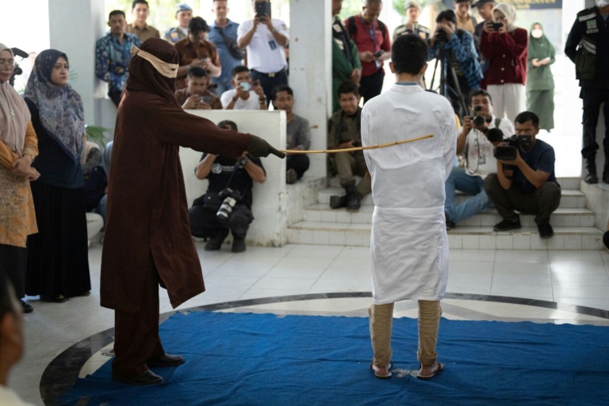 A man, found guilty of sexual relations with another man under the strict Islamic sharia law, is publicly flogged in Banda Aceh
