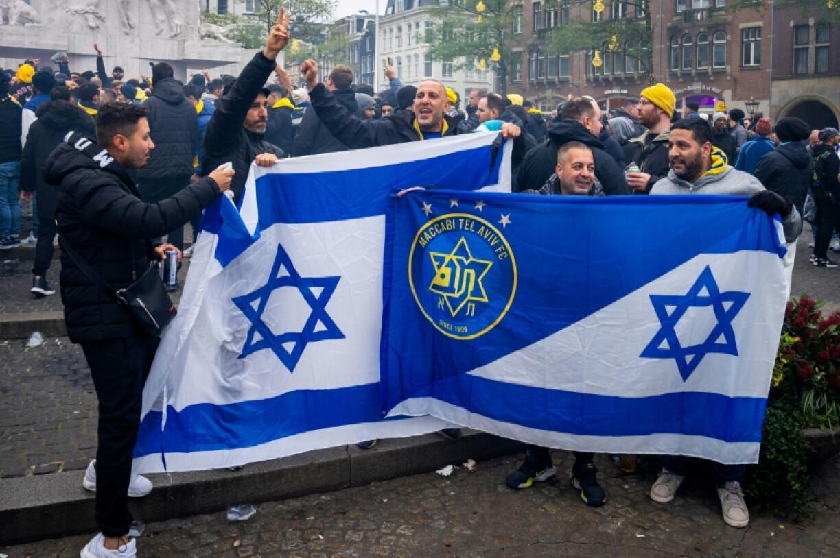 Les supporters du Maccabi Tel Aviv brandissent des drapeaux sur la place du Dam avant le match de football de la Ligue Europa entre l'Ajax et le Maccabi Tel Aviv, à Amsterdam, le 7 novembre 2024