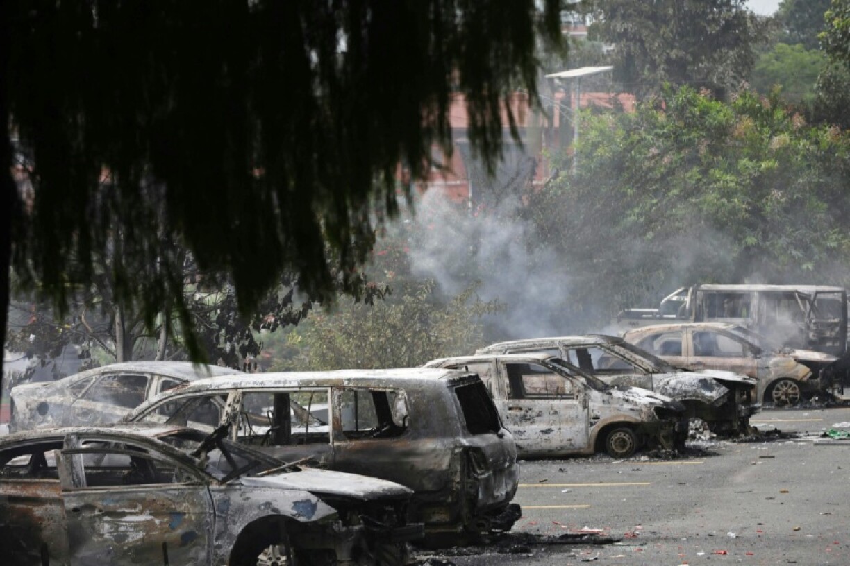 Charred remains of government vehicles lie inside the premises of the official residence of Nepal's prime minister