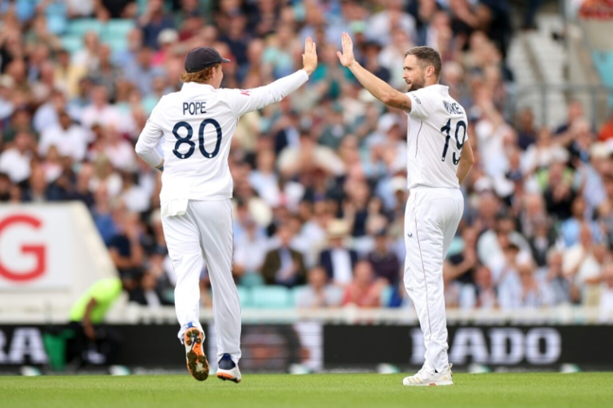 Chris Woakes (R) celebrates his dismissal of India's KL Rahul in the fifth Test at the Oval with England captain Ollie Pope (L)