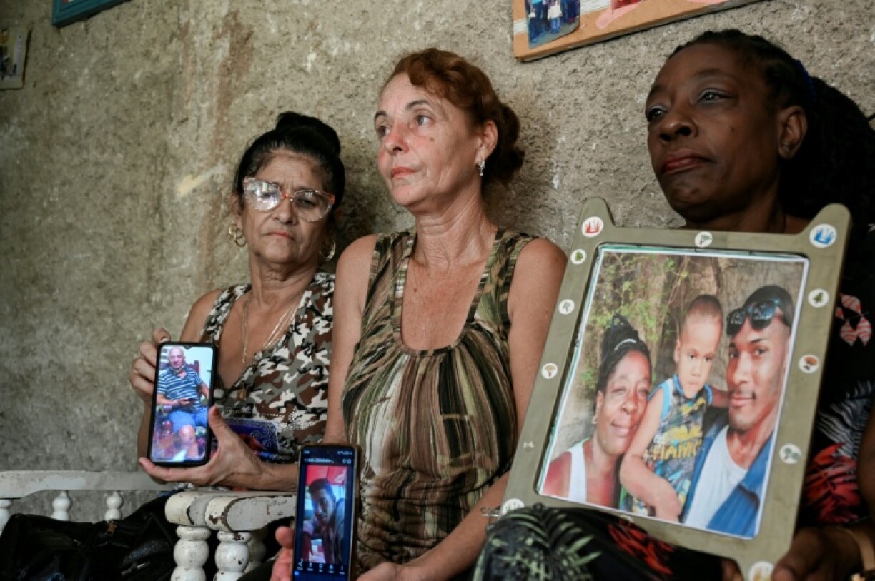 Cubans show pictures of their relatives who disappeared in January 2023 on a handmade migrant boat somewhere between Cuba and South Florida