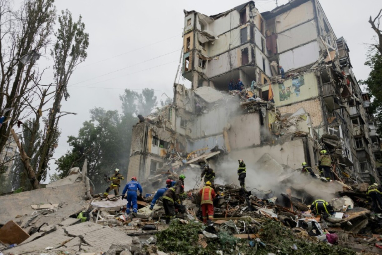 Rescuers clear debris at the site of Sofia and Mykyta's destroyed home