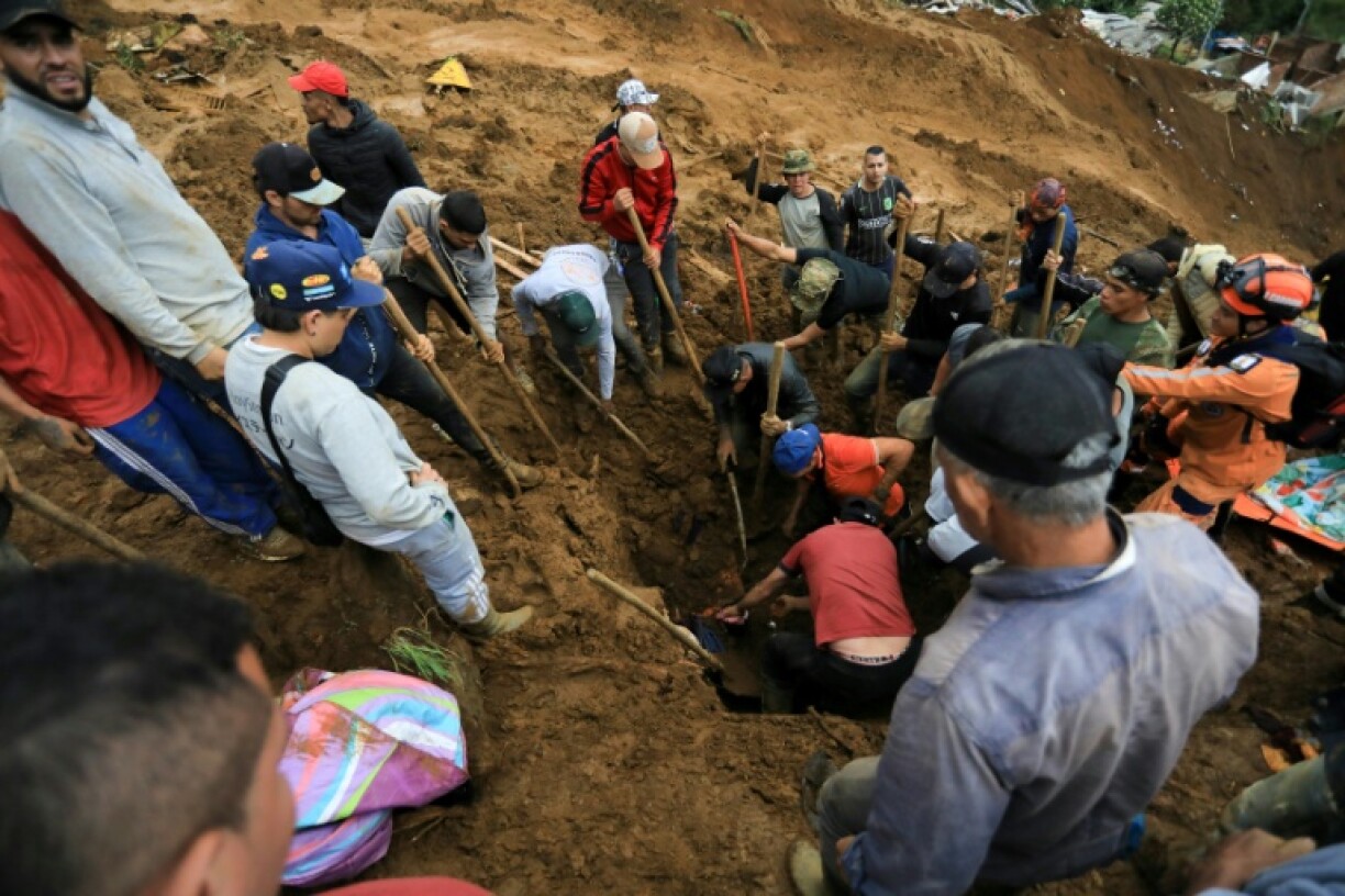 Locals help rescuers as they search for victims and survivors following a landslide that killed at least 10 people in Bello, Antioquia Department, Colombia