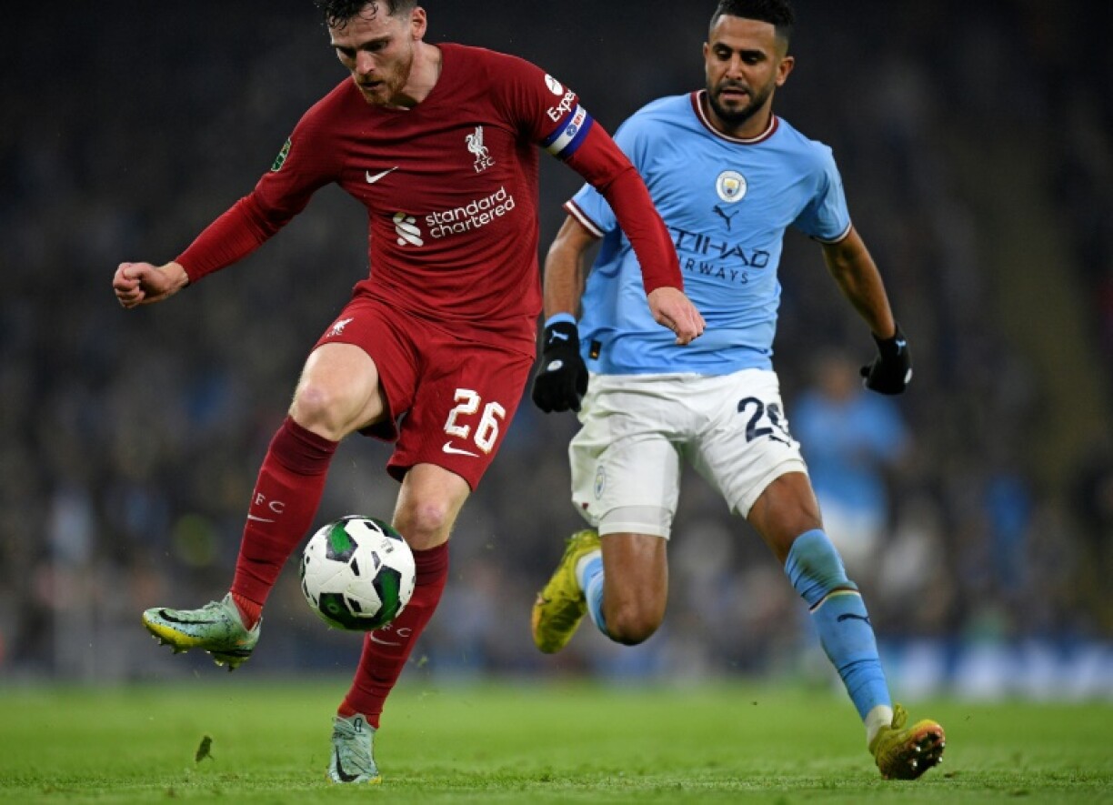 Le défenseur de Liverpool Andrew Robertson (g) devance l'attaquant de Manchester City Riyad Mahrez, le 22 décembre 2022 à Manchester