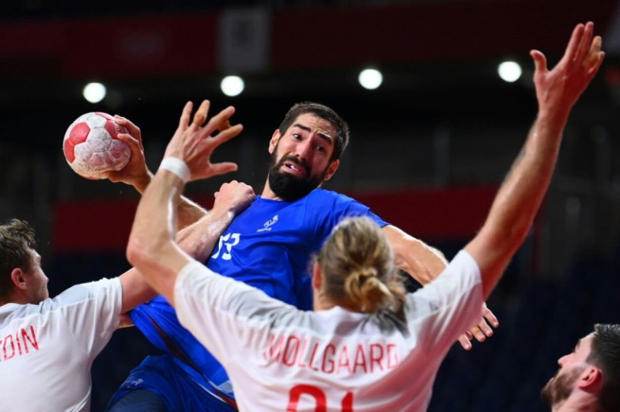 Le Français Nikola Karabatic tente un tir malgré la défense des Danois, lors de leur finale, le 7 août 2021 aux Jeux Olympiques de Tokyo 2020