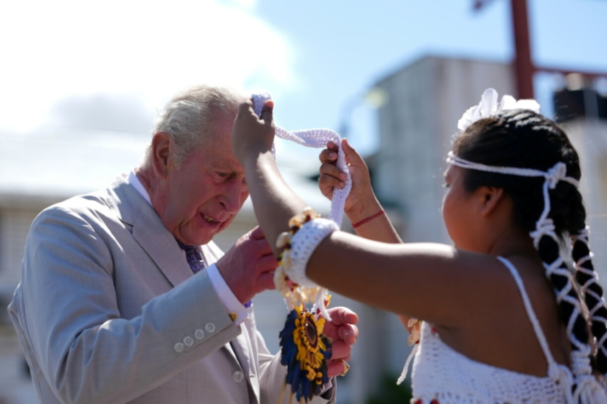 An Indigenous child gifts British King Charles a necklace in Guyana