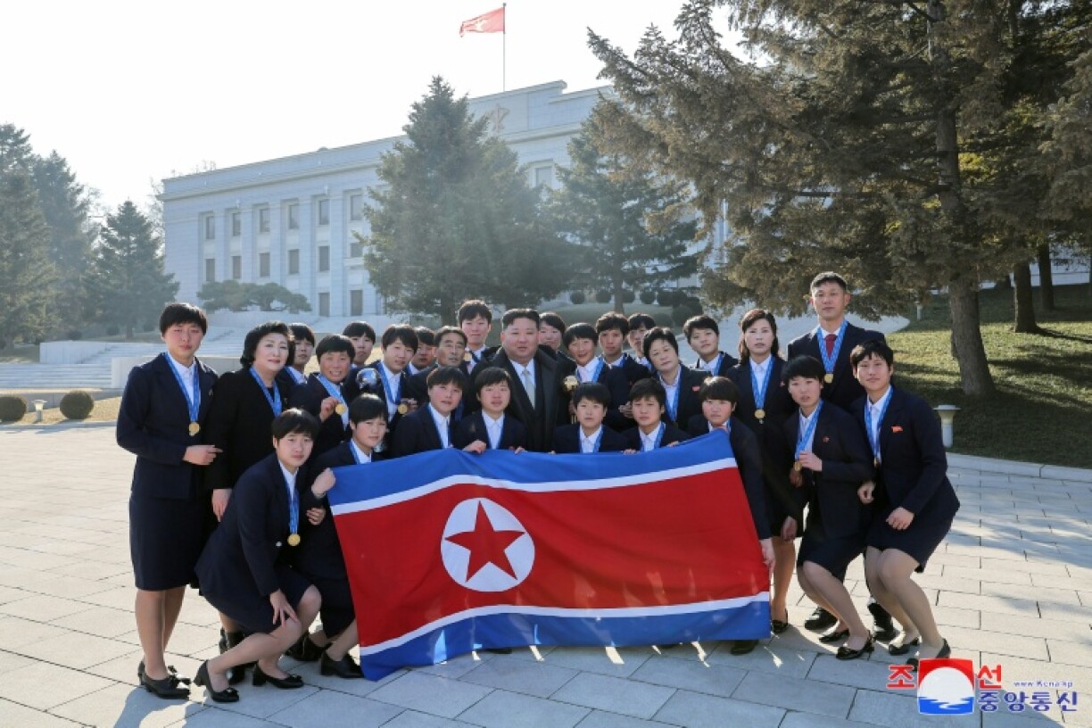 North Korea's leader Kim Jong Un (centre) poses with players and coaches who won the 2024 U-17 Women's World Cup outside the Party Central Committee headquarters building in Pyongyang. The U-17 side retained the World Cup at the weekend