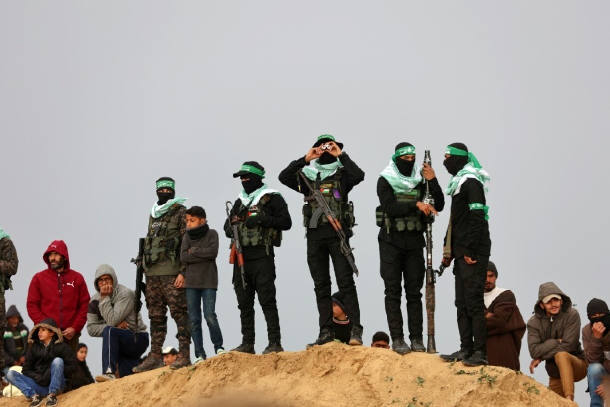 Des combattants du Hamas et des civils se rassemblent sur le lieu de la remise des corps d'otages israéliens à Khan Younes, dans le sud de la bande de Gaza, le 20 février 2025