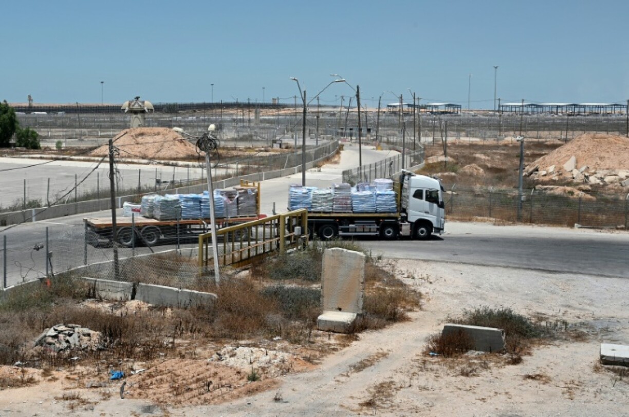 Un camion transportant de l'aide humanitaire pour la bande de Gaza roule près du poste-frontière de Kerem Shalom entre le sud d'Israël et la bande de Gaza, le 17 juin 2024