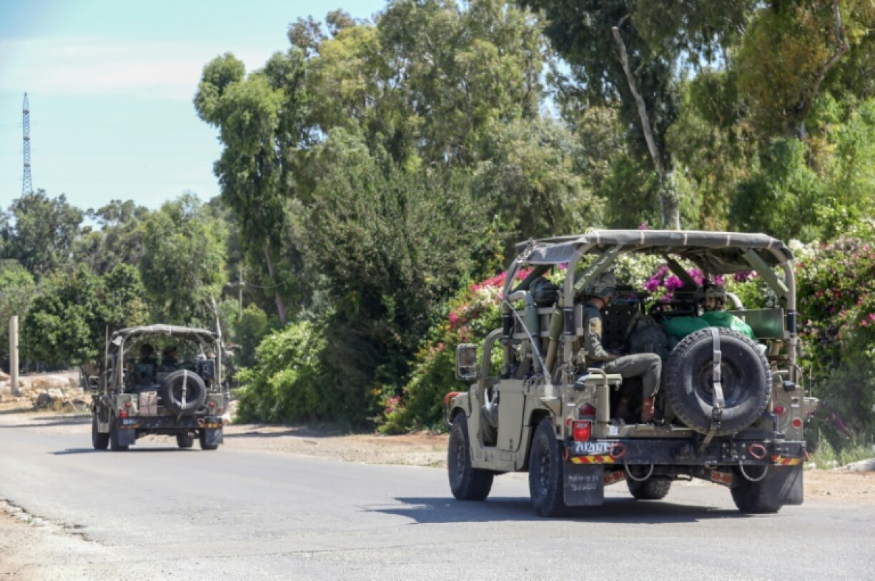Les forces de sécurité israéliennes à bord de véhicules à la recherche de suspects palestiniens près d'une forêt à côté de la ville d'Elad dans le centre d'Israël, le 8 mai 2022