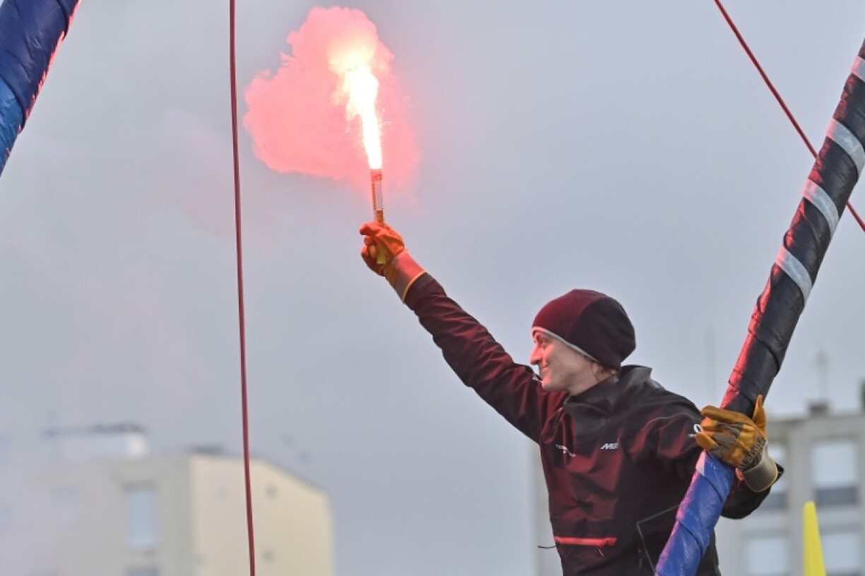 Justine Mettraux signals her arrival to watching supporters as she enters port in Sables-d'Olonne after finishing eighth in the Vendee Globe