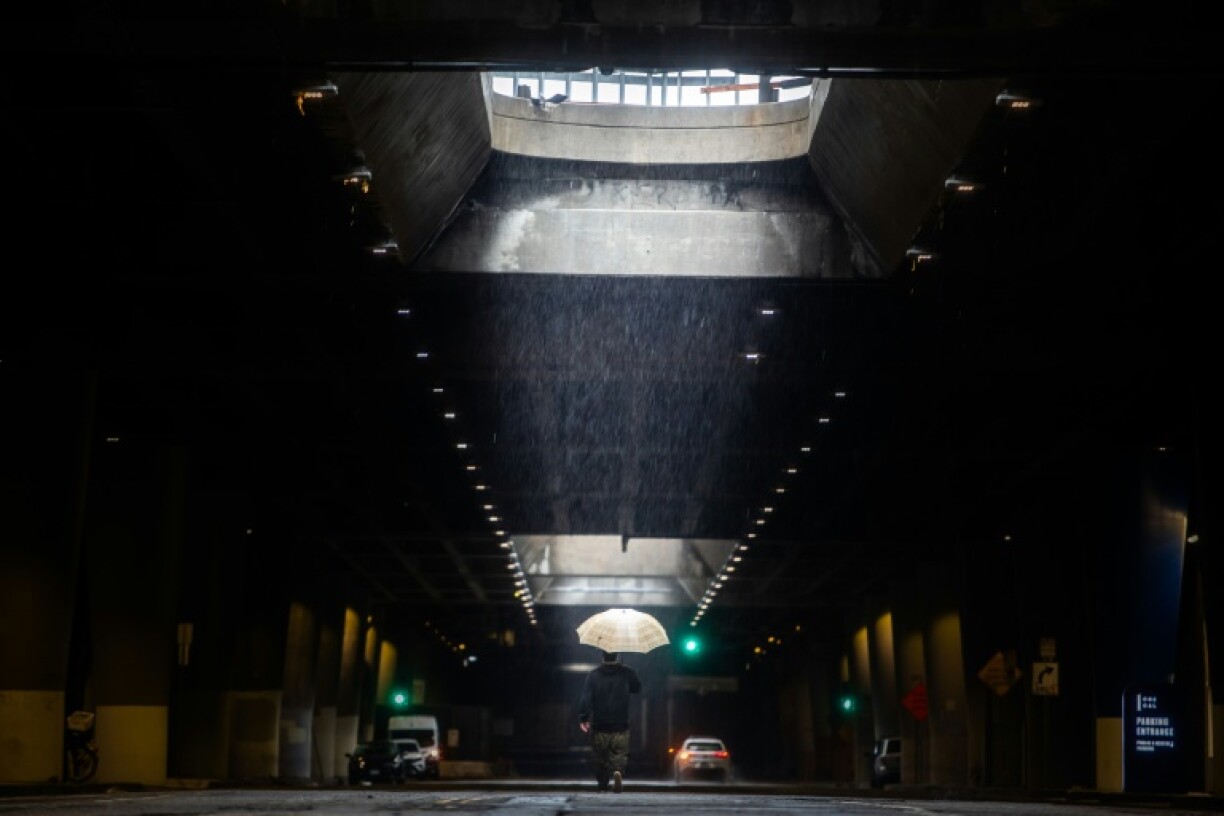 Un homme se promène à Los Angeles pendant les fortes pluies, le 24 décembre 2025