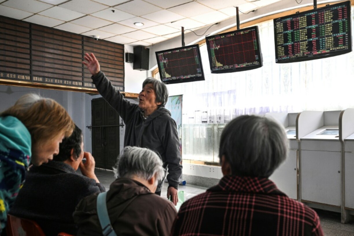 Investors monitor stock price movements at a securities company in Shanghai