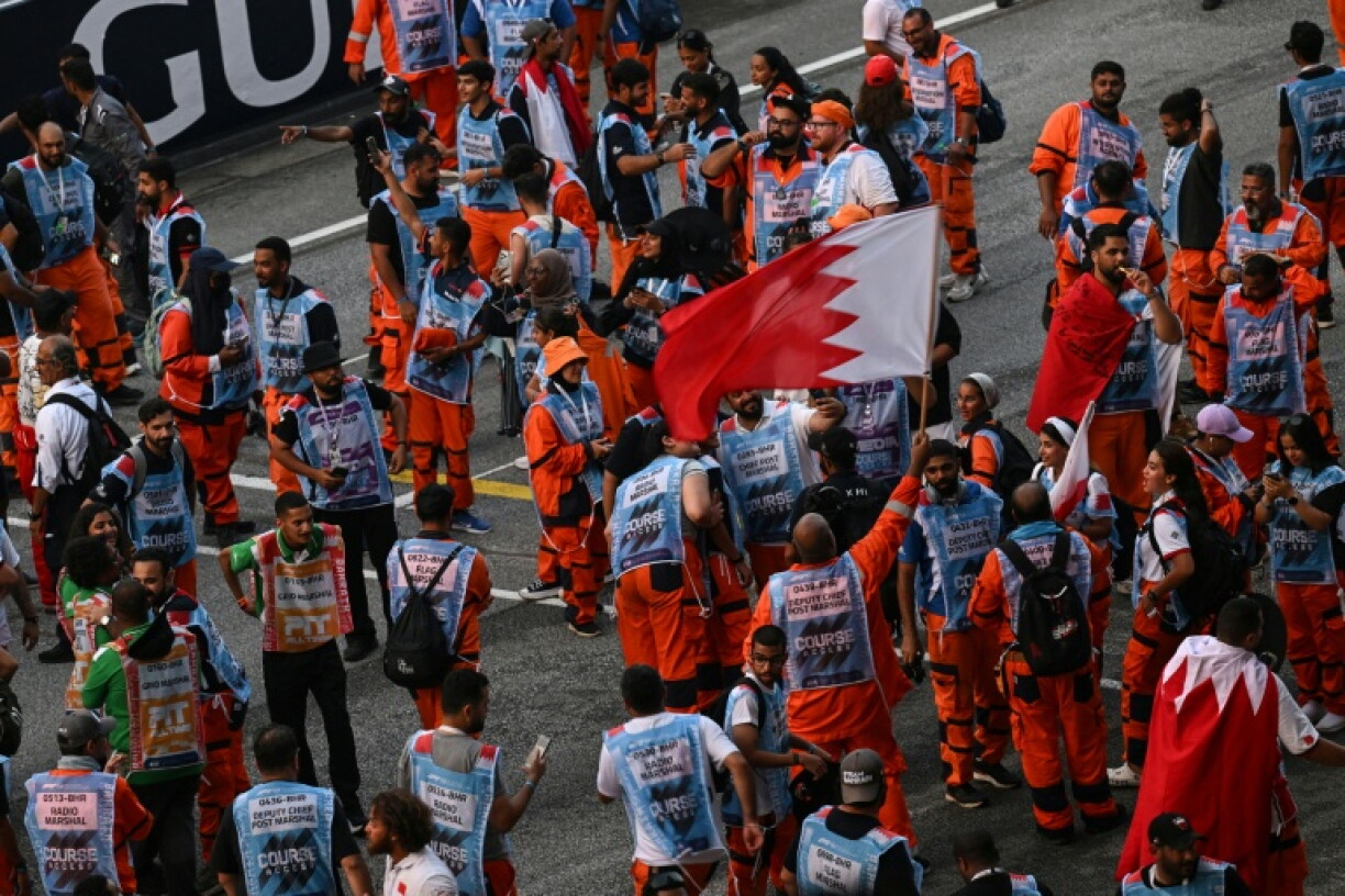 Marshals celebrate with Bahrain flags after the end of the Grand Prix in Sepang
