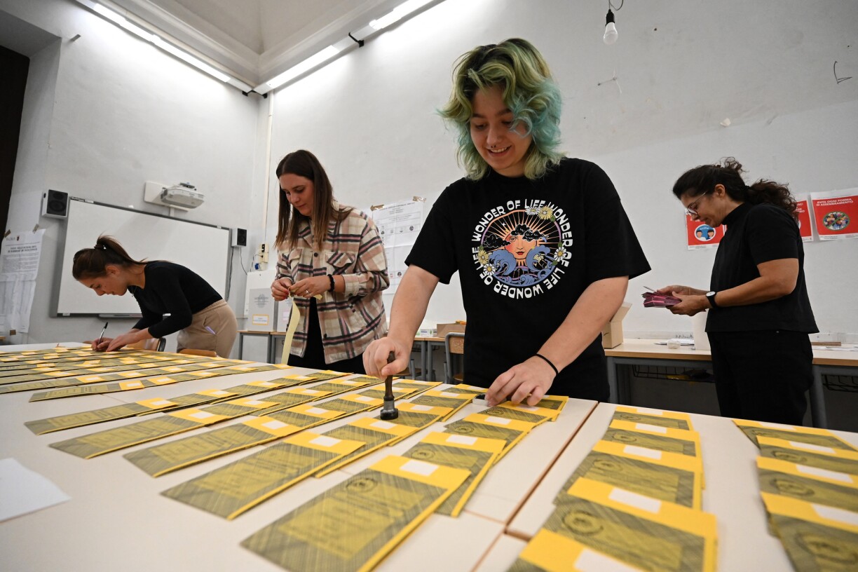 Volunteers prepare yellow ballot papers for the Senate vote at a polling station in Rome, on the eve of the country's legislative election.