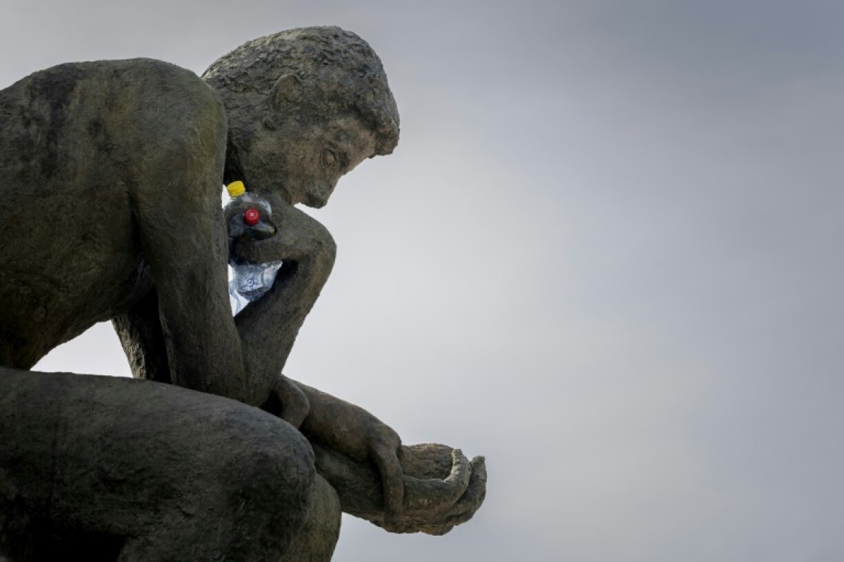 Benjamin Von Wong's installation 'The Thinker's Burden' has crushed plastic bottles in one hand