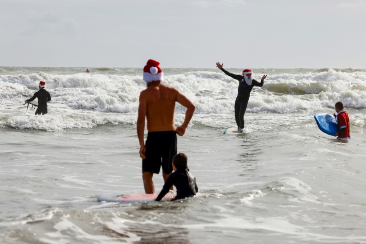 Des surfeurs habillés en Père Noël, le 24 décembre 2023