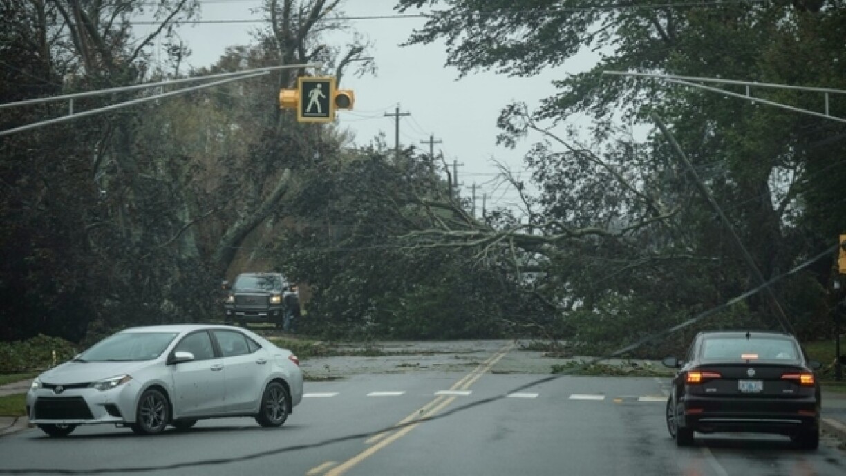 Des voitures circulent au milieu d'un chaos d'arbres et d'installations routières et électriques causé par l'ouragan Fiona, à Reserves Mines, dans l'est du Canada, le 24 septembre 2022