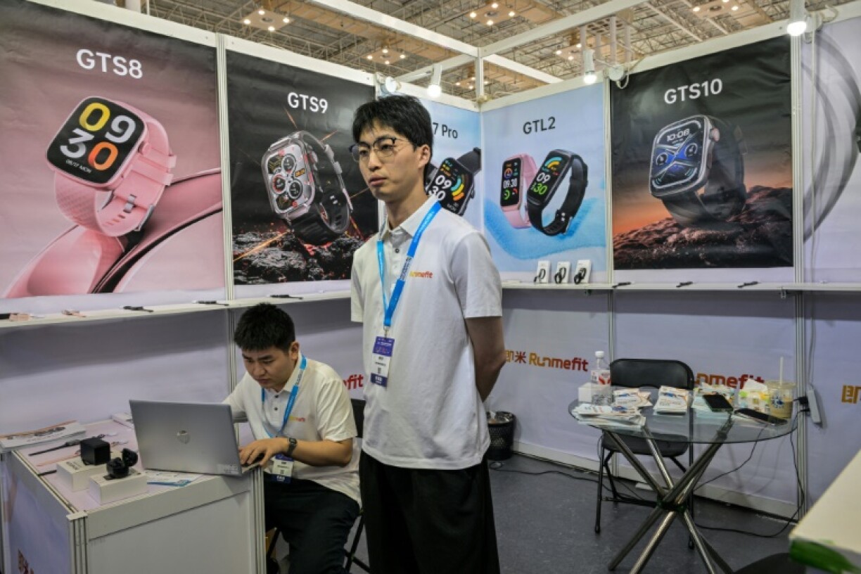 Han Zhongkai (C), 27, employee at his stand during the Ningbo Cross-Border E-commerce Expo Fair in Ningbo