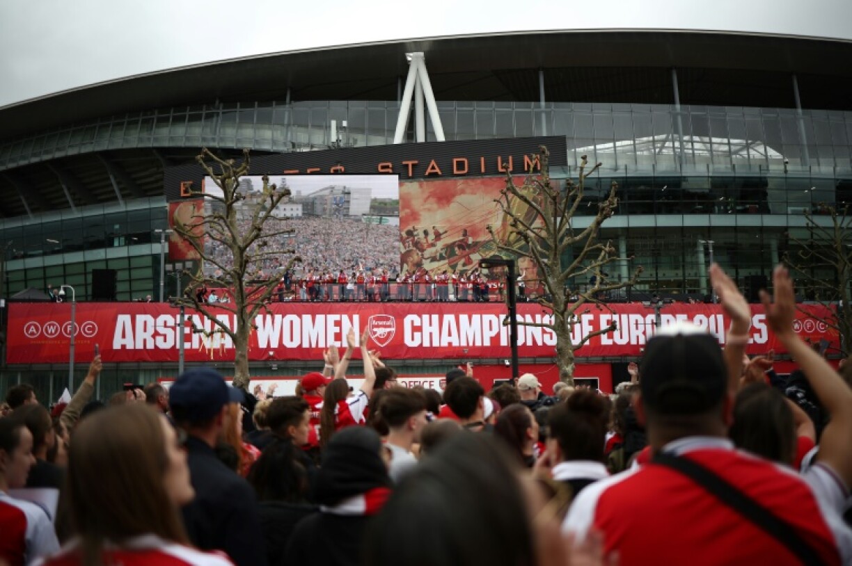 Arsenal's players celebrate with the UEFA Women's Champions League trophy during a parade outside the club's Emirates Stadium, in London