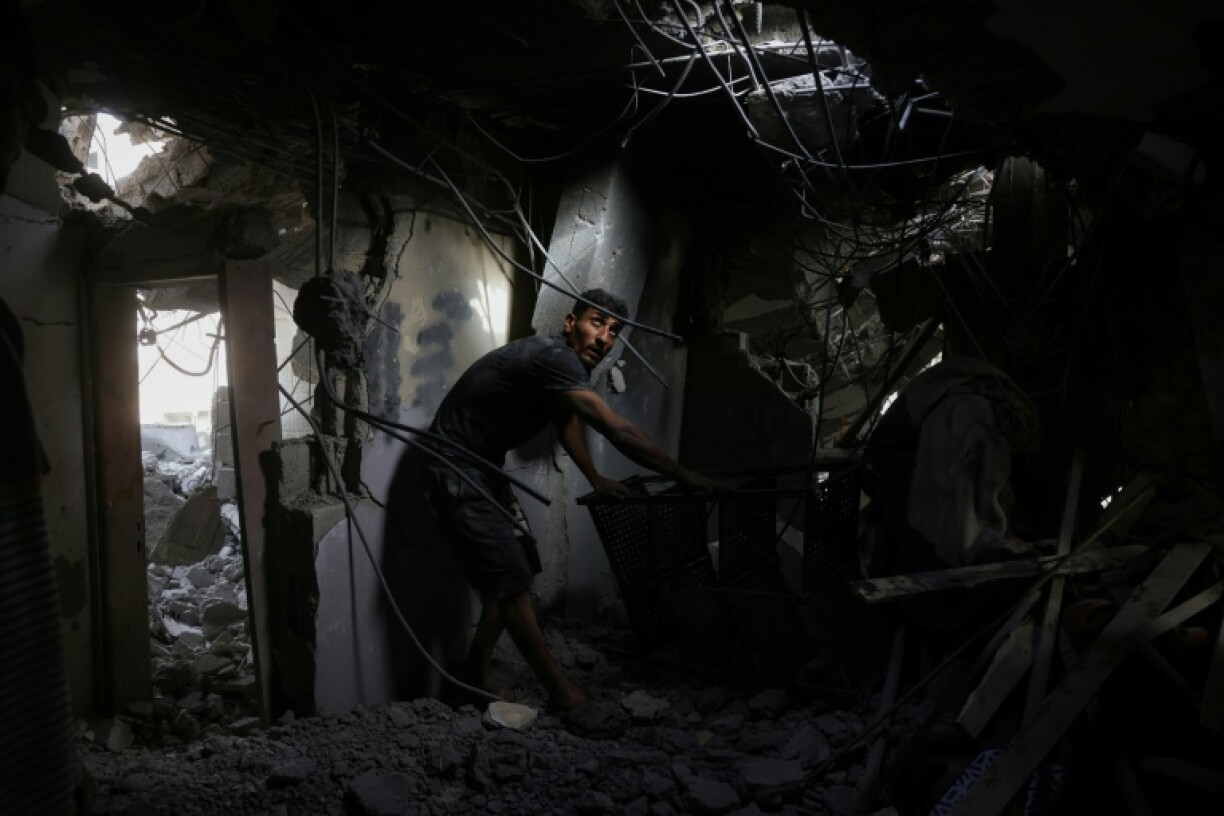 A Palestinian man searches the rubble of a house hit in Israeli strikes on the northern Gaza Strip