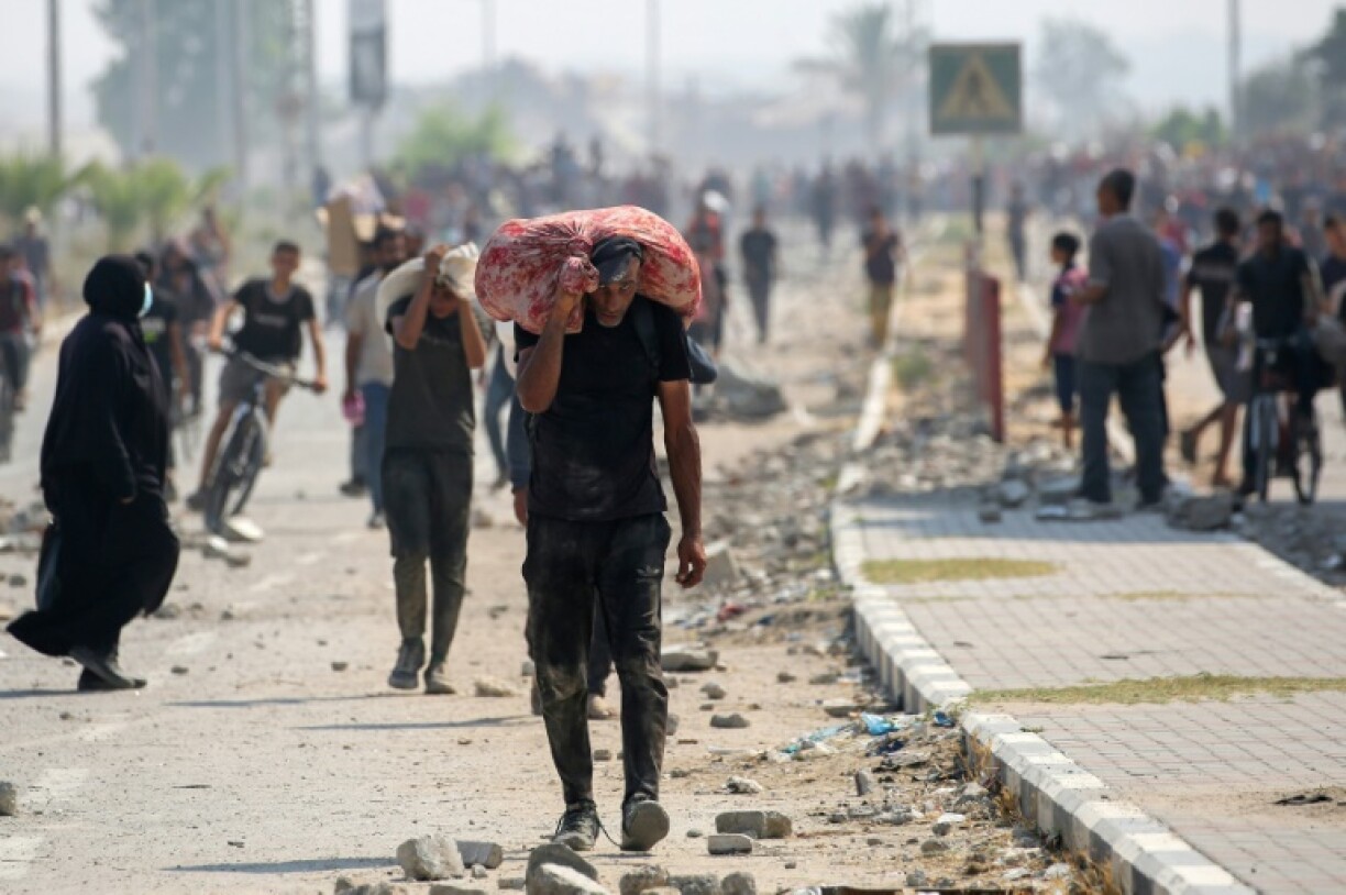 Displaced Palestinians at the Nuseirat refugee camp in Gaza seen hauling hard-to-get food parcels and other items