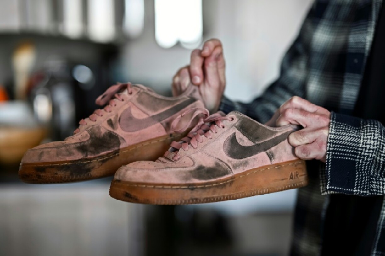 Lynskey holds the shoes he wore the day of the attack