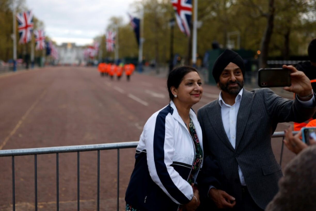 Un couple prend un selfie sur le parcours du cortège du couronnement, le 4 mai 2023 à Londres