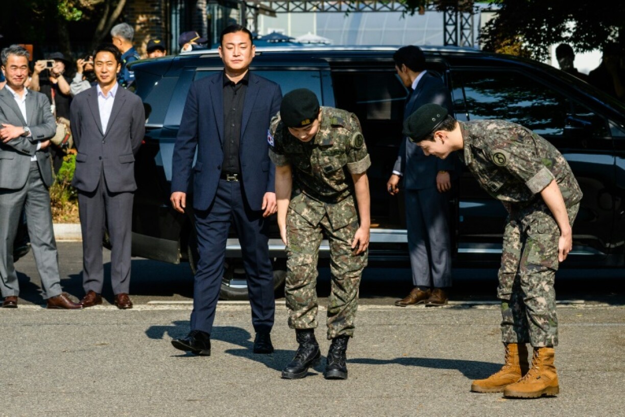 Jungkook (R) and Jimin (L) of K-pop supergroup BTS bow shortly after their release from 18 months of South Korean military service