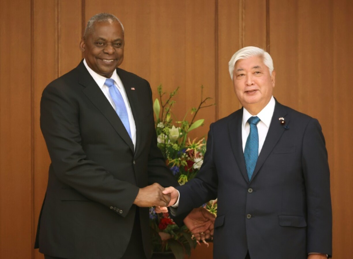 US Secretary of Defense Lloyd Austin (L) shakes hands with Japan's Defence Minister Gen Nakatani (R) prior to their talks at the Ministry of Defence in Tokyo