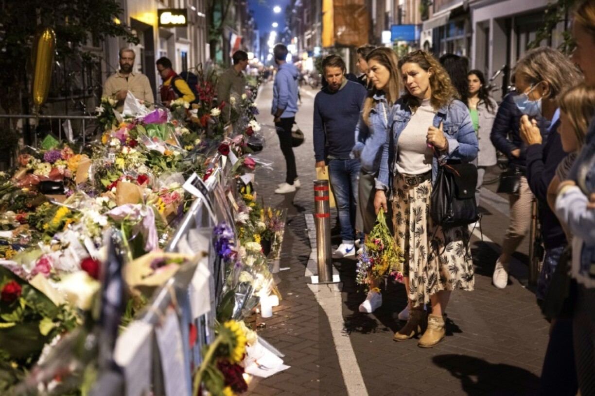 Des membres du public déposent des fleurs le 16 juillet 2021 à l'endroit où le journaliste néerlandais Peter R. de Vries a été abattu à Amsterdam