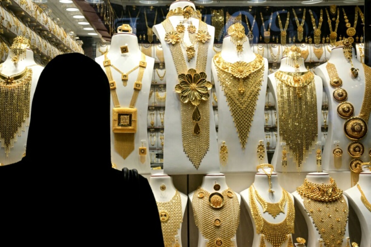 A woman examines gold jewellery at a shop in Dubai