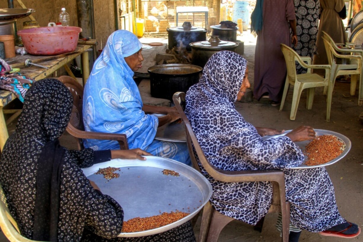 Women sift through grains at a local kitchen in Khartoum North