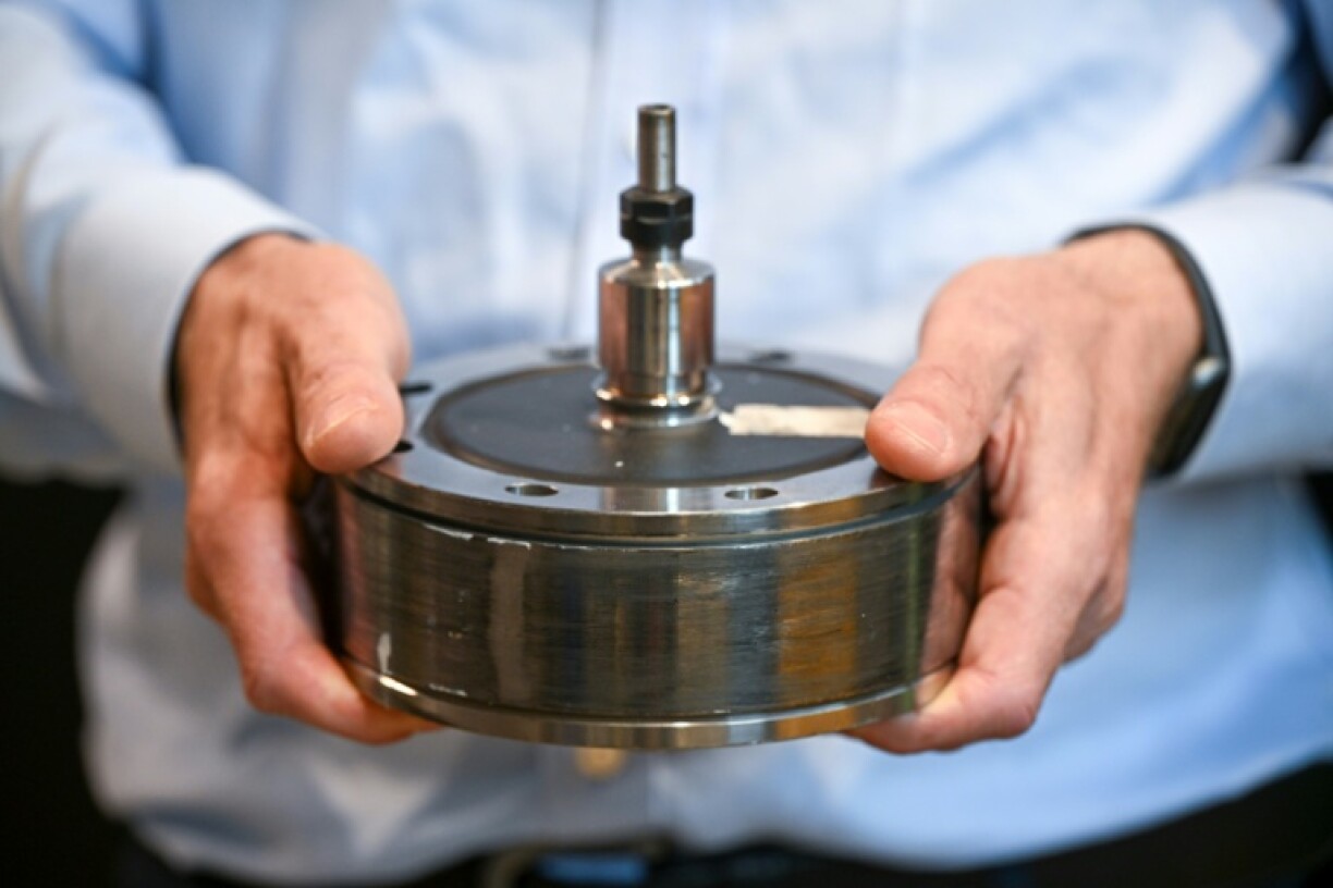 Keith Pullen, chief technical officer at Levistor, holds a flywheel inertia rotor at the company's workshop which can help bring stability to the electricity grid