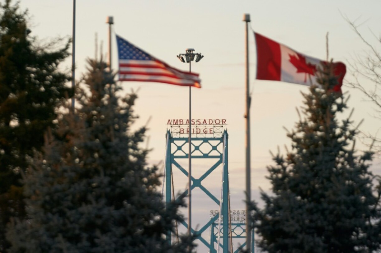 Canadian and American flags fly on the Canadian side of the Ambassador Bridge in Windsor, Canada on March 8, 2025