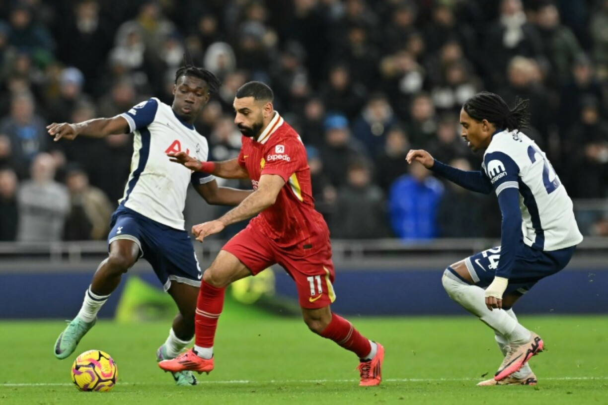 Liverpool star Mohamed Salah (C) bursts between Yves Bissouma (L) and Djed Spence of Tottenham Hotspur during a Premier League match in London on December 22, 2024.