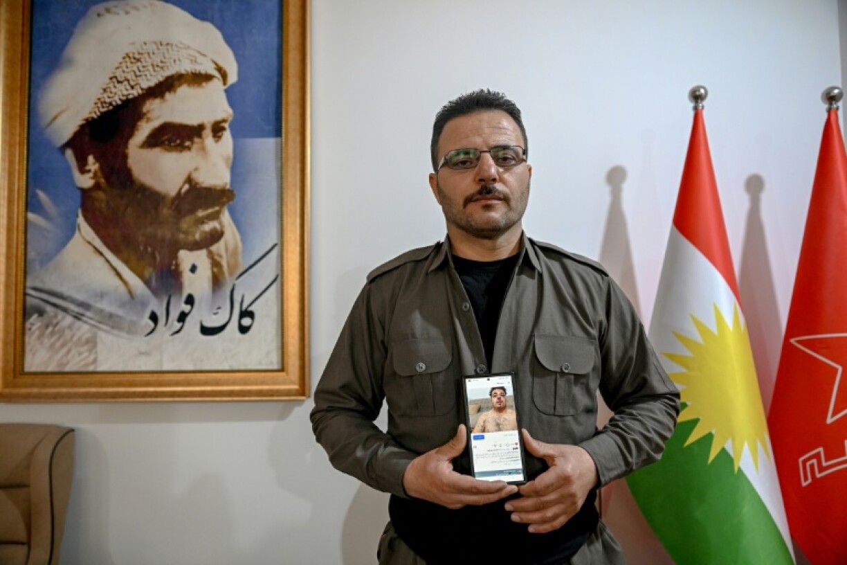 Aresto Pasbar, un Iranien qui a fui le pays après avoir rejoint les manifestations antigouvernementales de 2022, montre une photo de ses blessures sur un téléphone portable dans une maison de Souleimaniyeh, le 13 mars 2026 en Irak