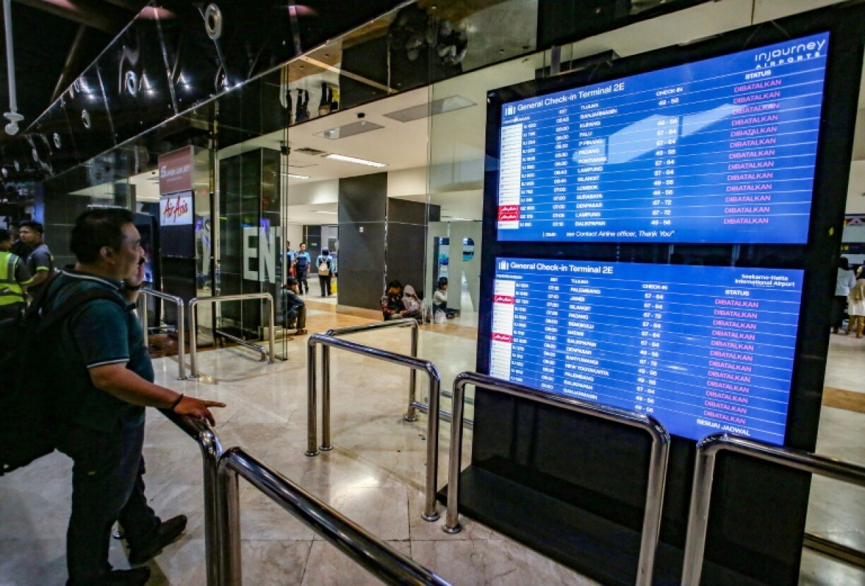 Un voyageur à l'aéroport Soekarno-Hatta de Tangerang après l'éruption du volcan Anak Krakatoa consulte le tableau des départs pour connaître le statut des vols, le 6 septembre 2026 en Indonésie