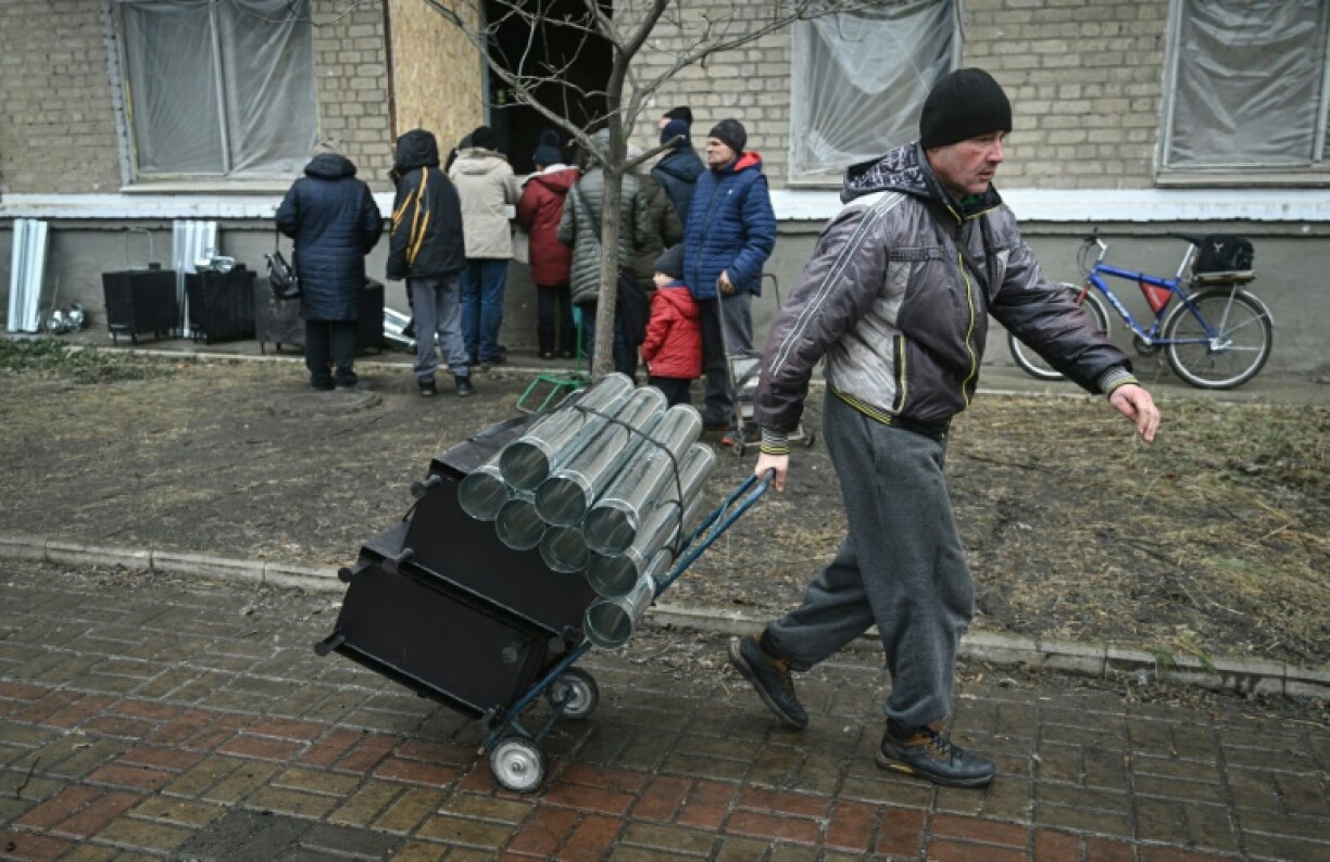 Un habitant transporte un poêle à bois distribué par des volontaires, le 16 décembre 2022 à Bakhmout, dans la région de Donetsk, en Ukraine