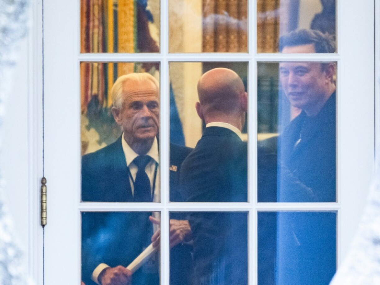 (FILES) (L-R) Senior Counselor to the President for Trade and Manufacturing, Peter Navarro, White House deputy chief of staff for policy and US homeland security advisor Stephen Miller, and Elon Musk speak inside the Oval Office of the White House before boarding Marine One with unseen US President Donald Trump in Washington, DC on March 14, 2025. Elon Musk on April 8 described Peter Navarro, a senior White House trade advisor, as