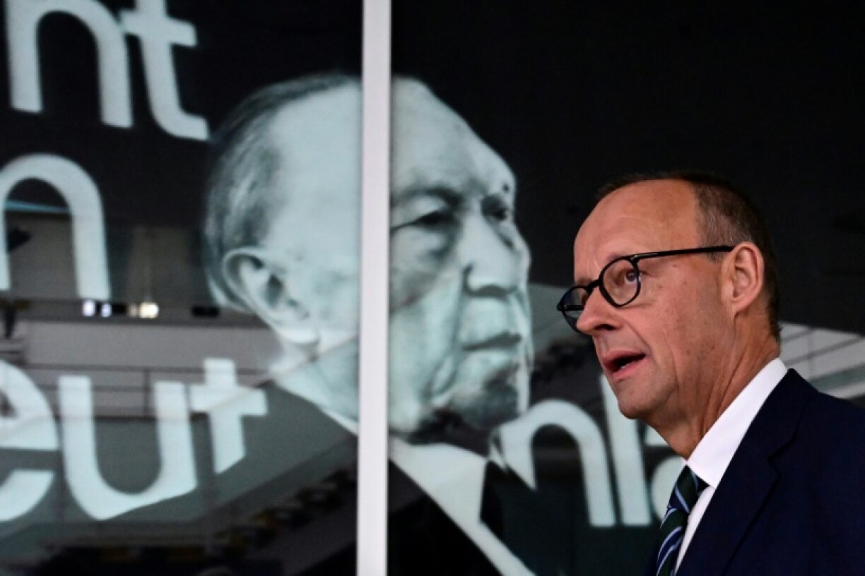 CDU leader Friedrich Merz before a portrait's of the party's first chancellor Konrad Adenauer