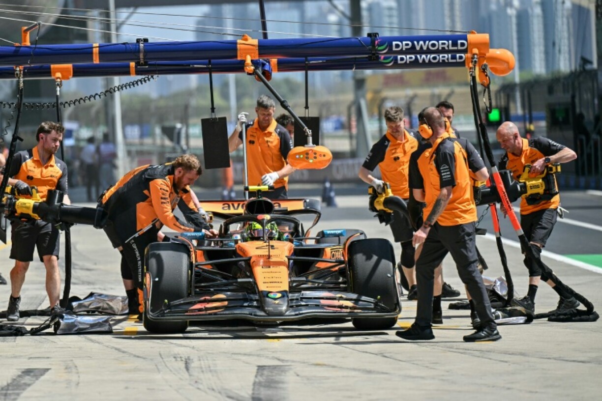 Mechanics work on the car of McLaren's British driver Lando Norris in the pits during the first practice session of the Formula One Chinese Grand Prix