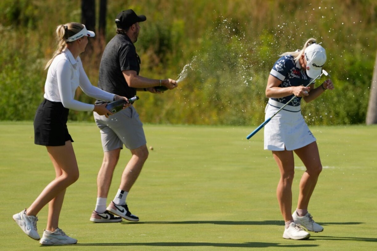 England's Charley Hull, right, is sprayed with champagne on the 18th green after winning the LPGA Queen City Championship