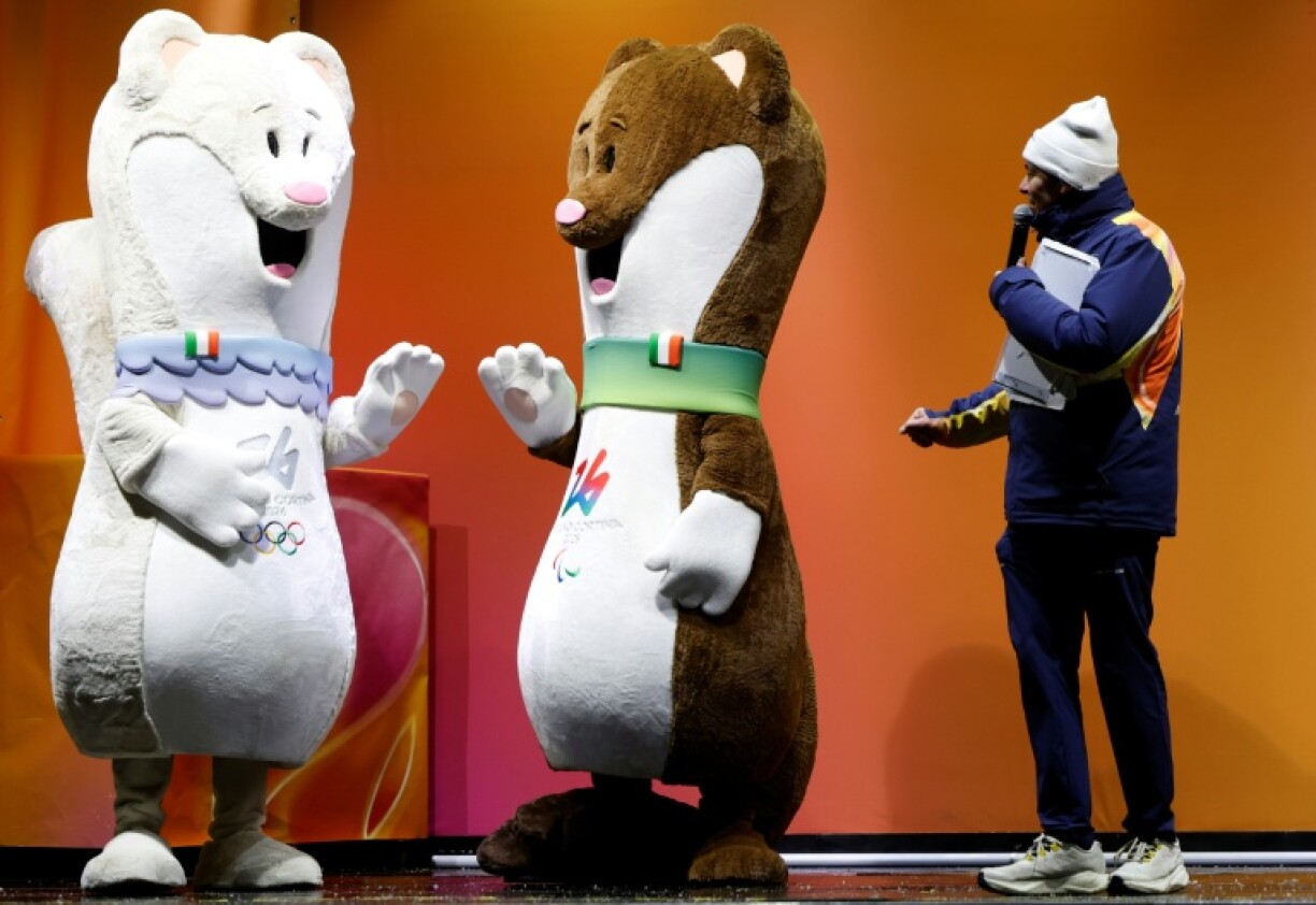 Les hermines Milo (d) et Tina, mascottes des Jeux olympiques de Milan-Cortina, à Cortina d’Ampezzo avant le dernier relais de la flamme olympique dans la ville, le 26 janvier 2026