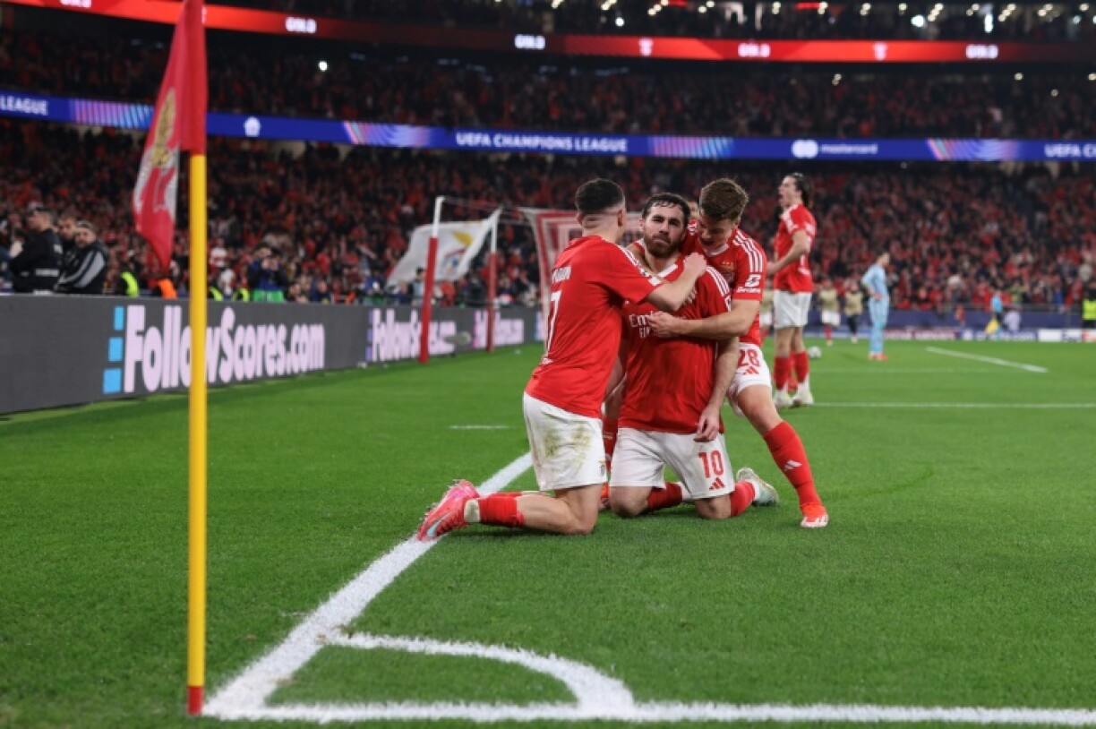 Benfica's Turkish midfielder Orkun Kokcu (C) celebrates with teammates after scoring their third goal against Monaco